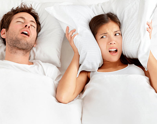 A woman being kept awake by her husband's snoring from Sleep Apnea